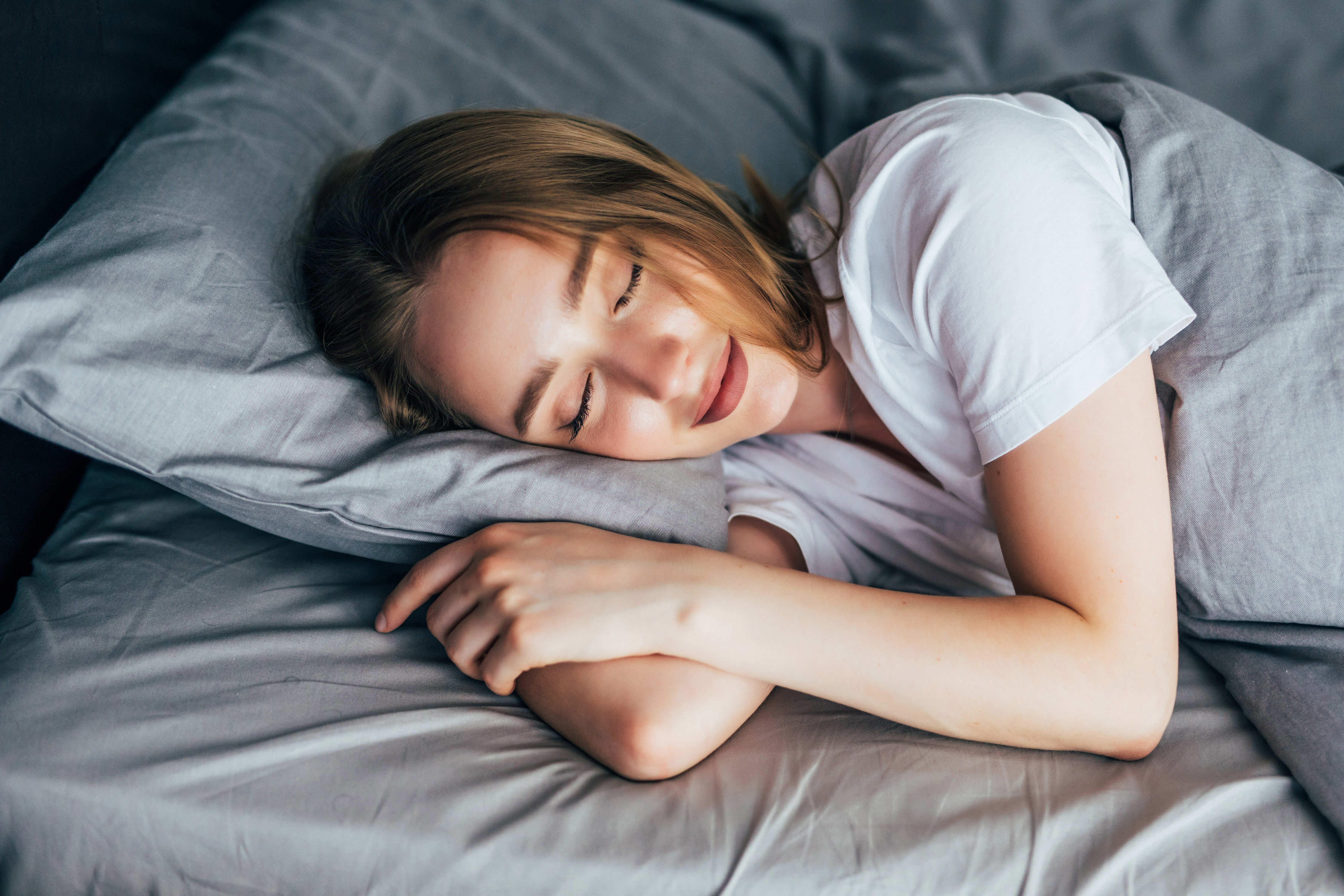 Beautiful young smiling woman sleeping in bed