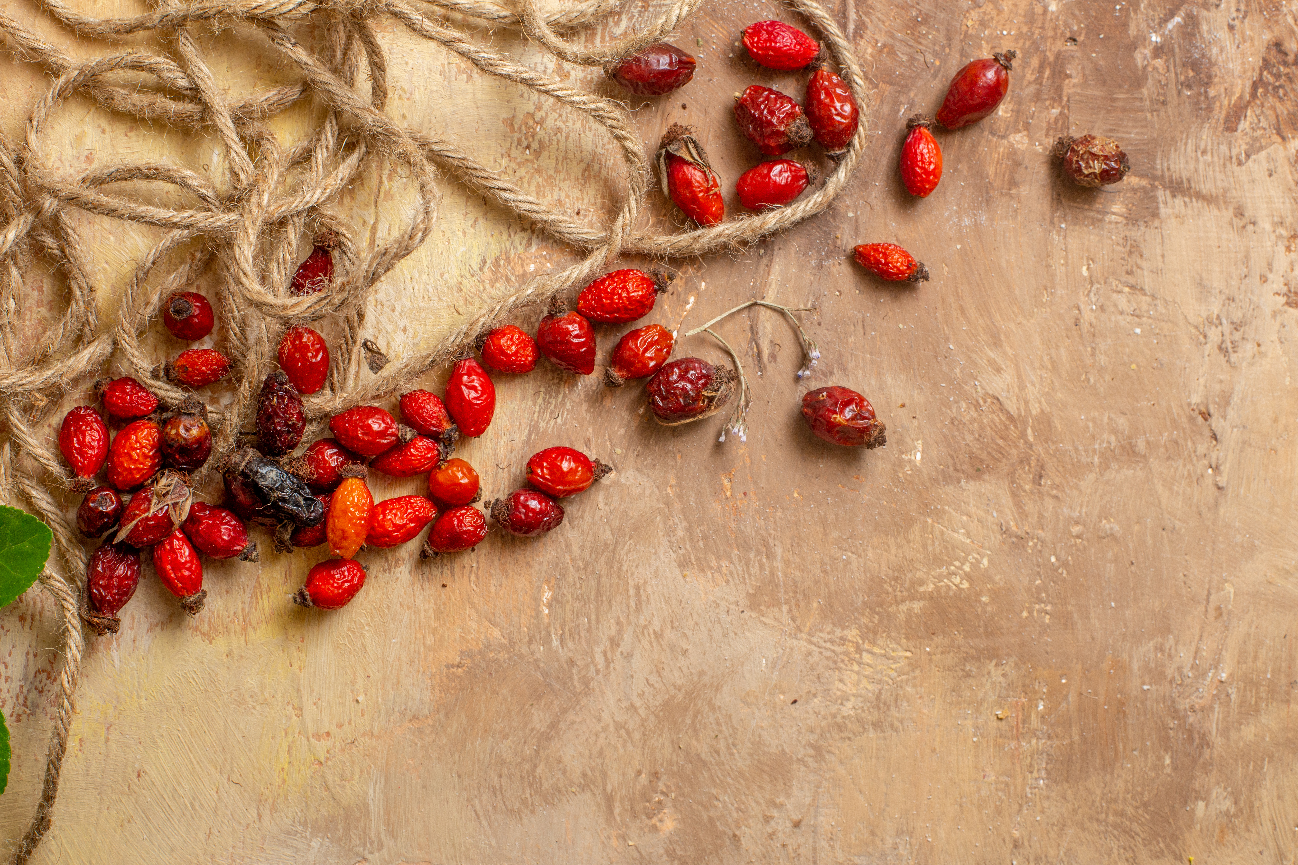 top-view-dried-red-berries-with-ropes-wooden-desk-red-fruit-berry